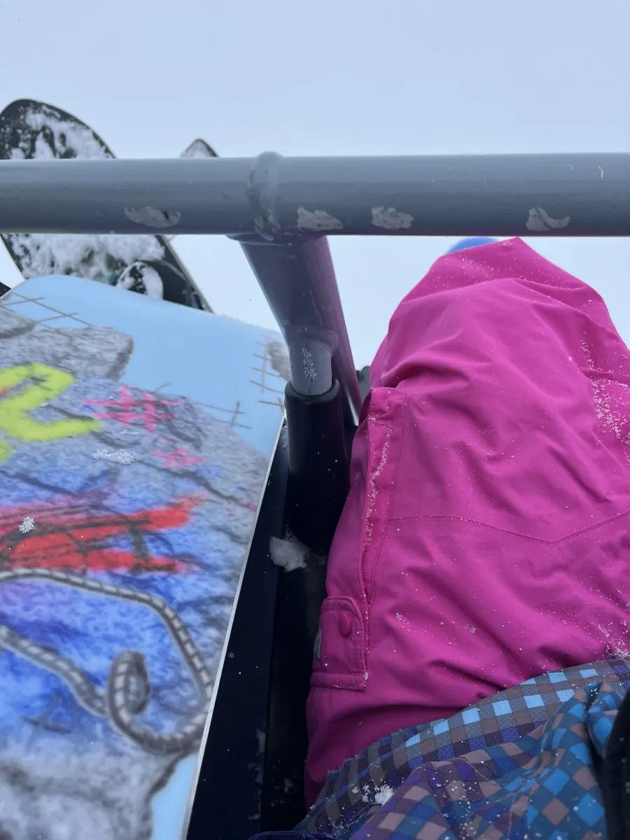 Snowboarding up a chairlift in the snow